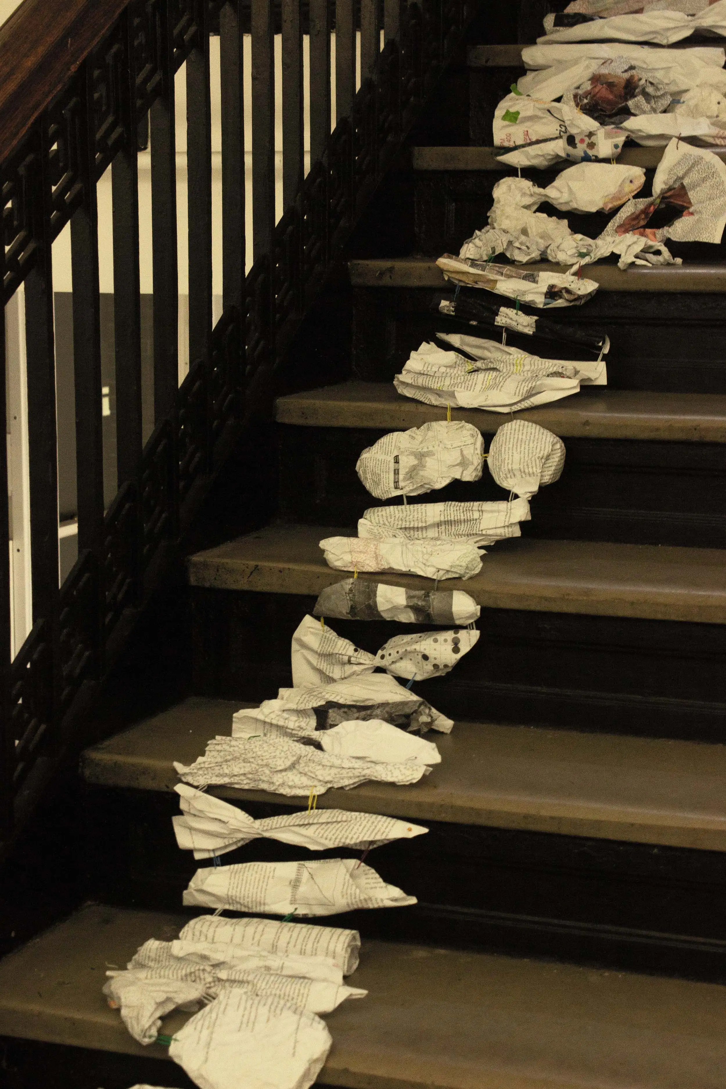 Paper beings descending the staircase